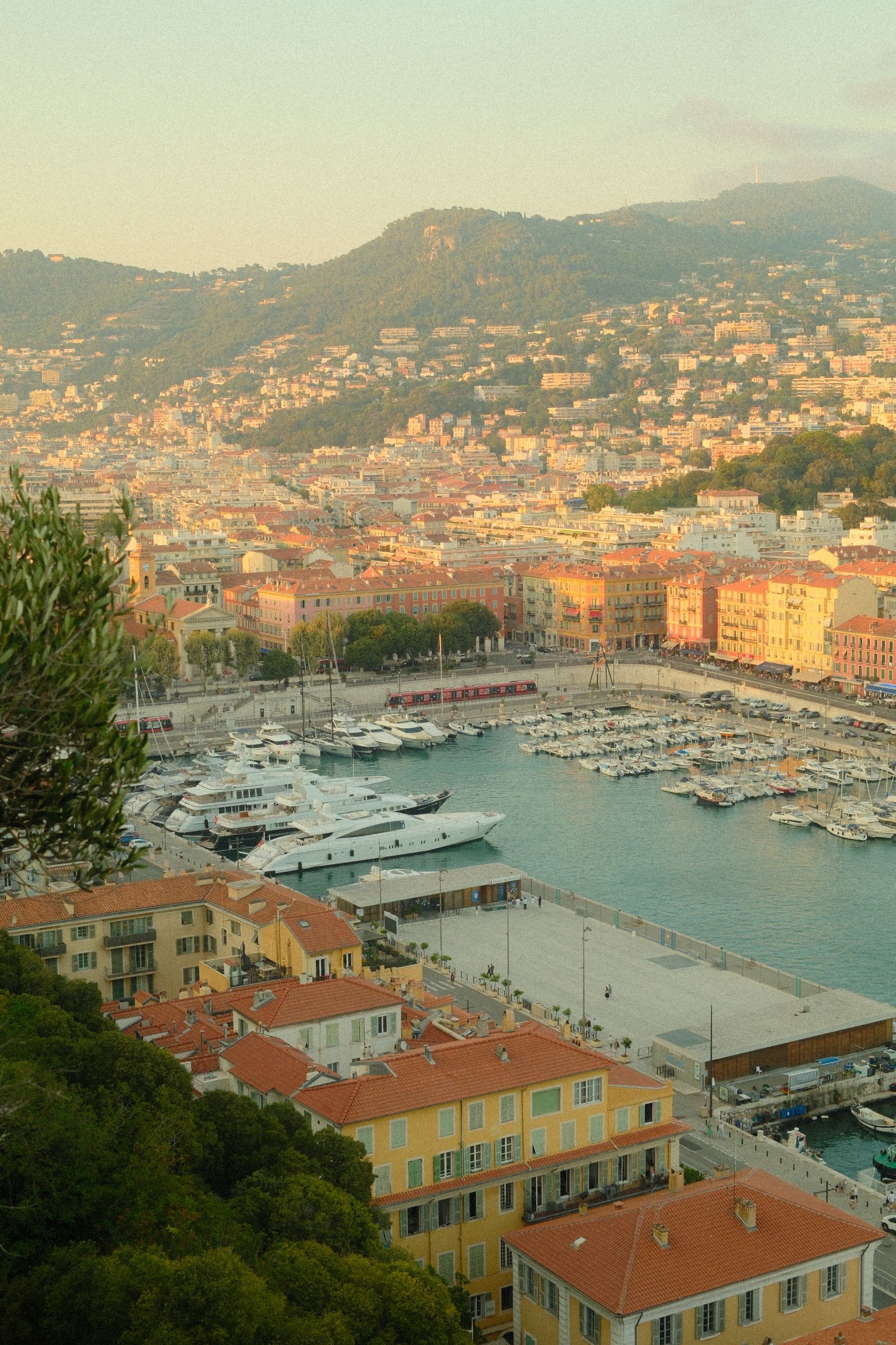 Le port de Nice et les collines dans la lumière dorée du soir